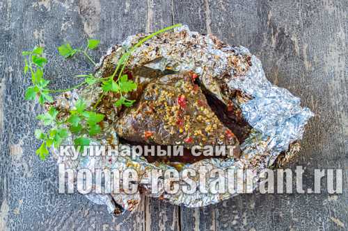 На противень постелить фольгу, смазать растительным жиром, выложить стейки, а сверху положить кружочки томатов